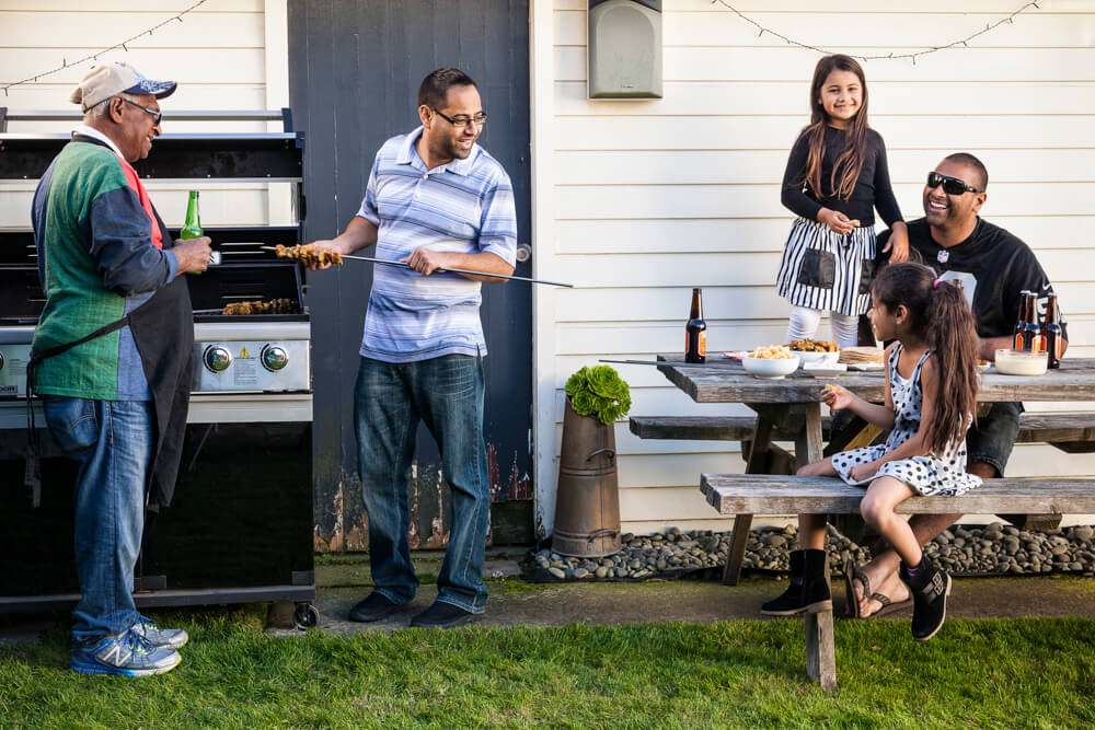 father, son and kids having BBQ in the backyard
