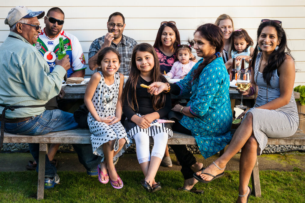 Ganda family barbeque in the backyard with children, kids, babies, grandparents and parents, drinking eating Gujarati BBQ food