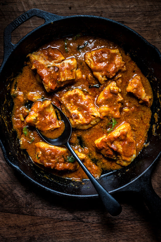 Fish Curry Gujarati Style, in black frypan with black spoon