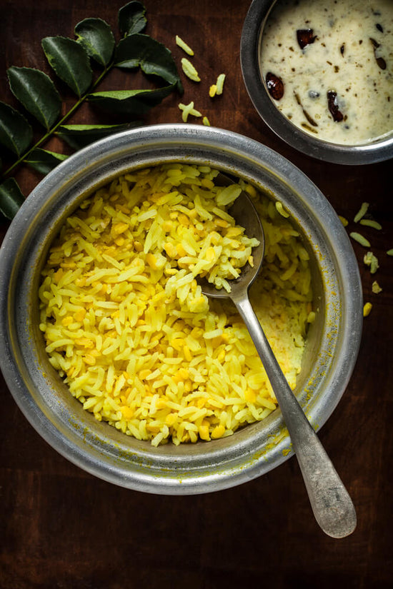 Kitchdi is a famous dish in Gujarat. It is made with rice and lentils, and it is very healthy and nutritious. bowl of kadhi as complimet