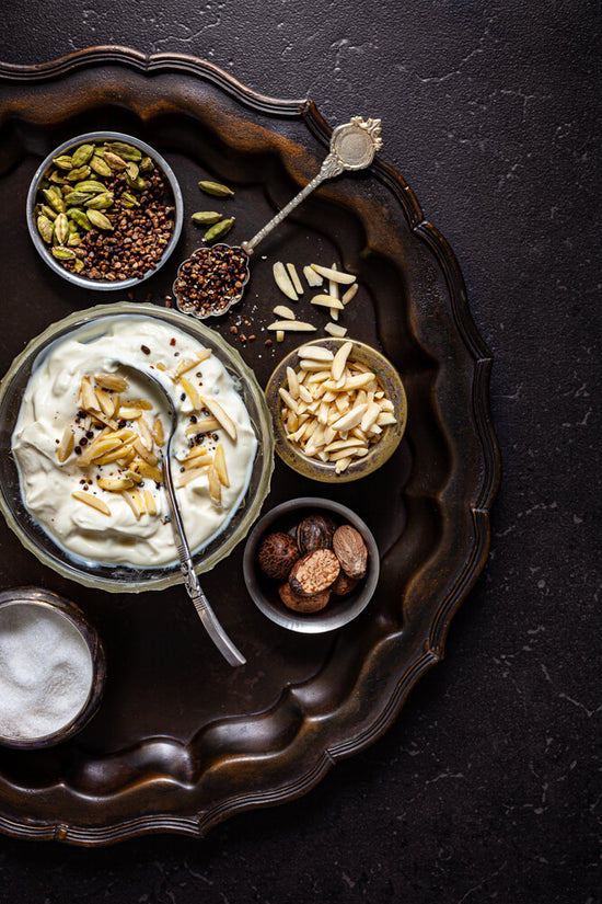 Shrikhan tray with toppings of sliced almonds, nutmeg, cardamom and sugar