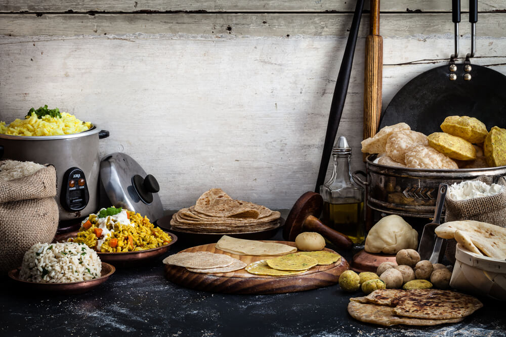 A selection on Gujarati breads and rice, chorka and rotli dishes, biryani, cumin rice, kitchdi, puri, poori, tikki poori, thepla, gahri rotli