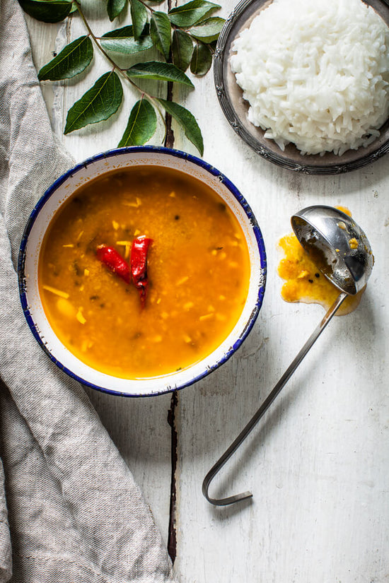 Gujarati dal, with rice, known as dal bhat and curry leaves in background