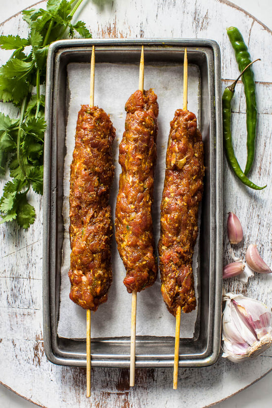 masala infused lamb mince koftas on skewers ready to cook