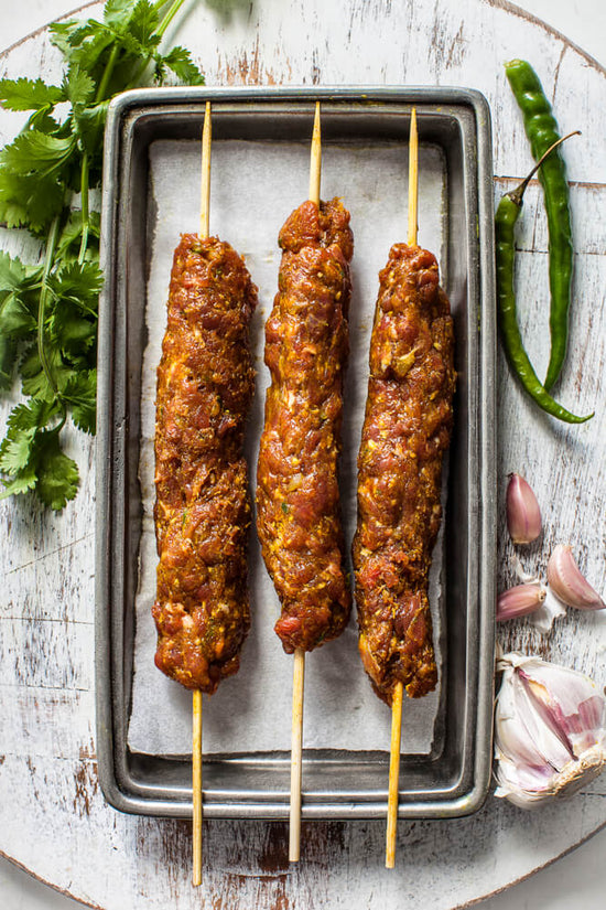 masala infused lamb mince koftas on skewers ready to cook