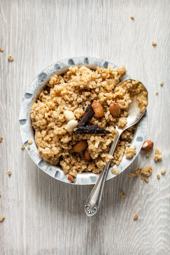 Gujarati Lapsi, broken wheat in bowl, kadhi topped with peanuts and sultanas