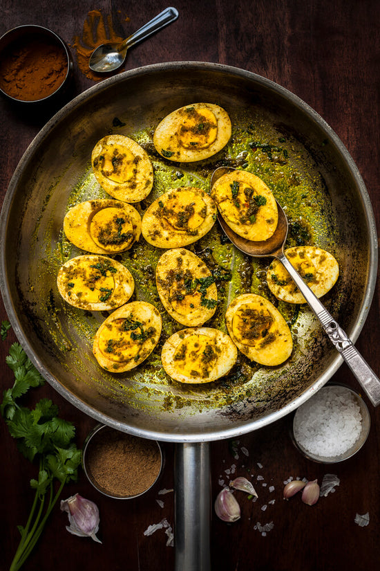 masala eggs, curried eggs in frypan with spices about the frypan