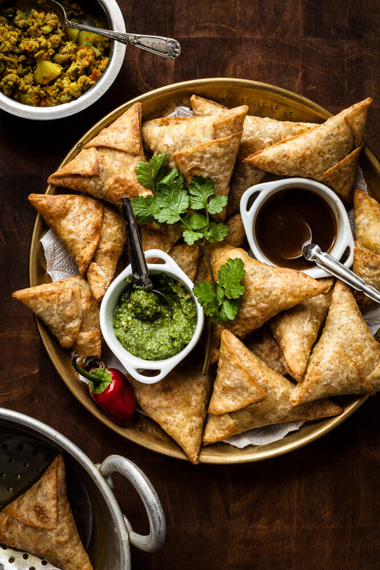 Samosa tray with Coriander chutney, meat filling, and date and tamarind chutney.