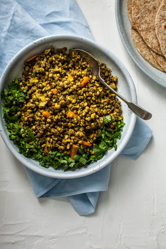 Gujarati Vadu, vadhu, Sprouted mung beans in a bowl topped with chopped coriander with rotli